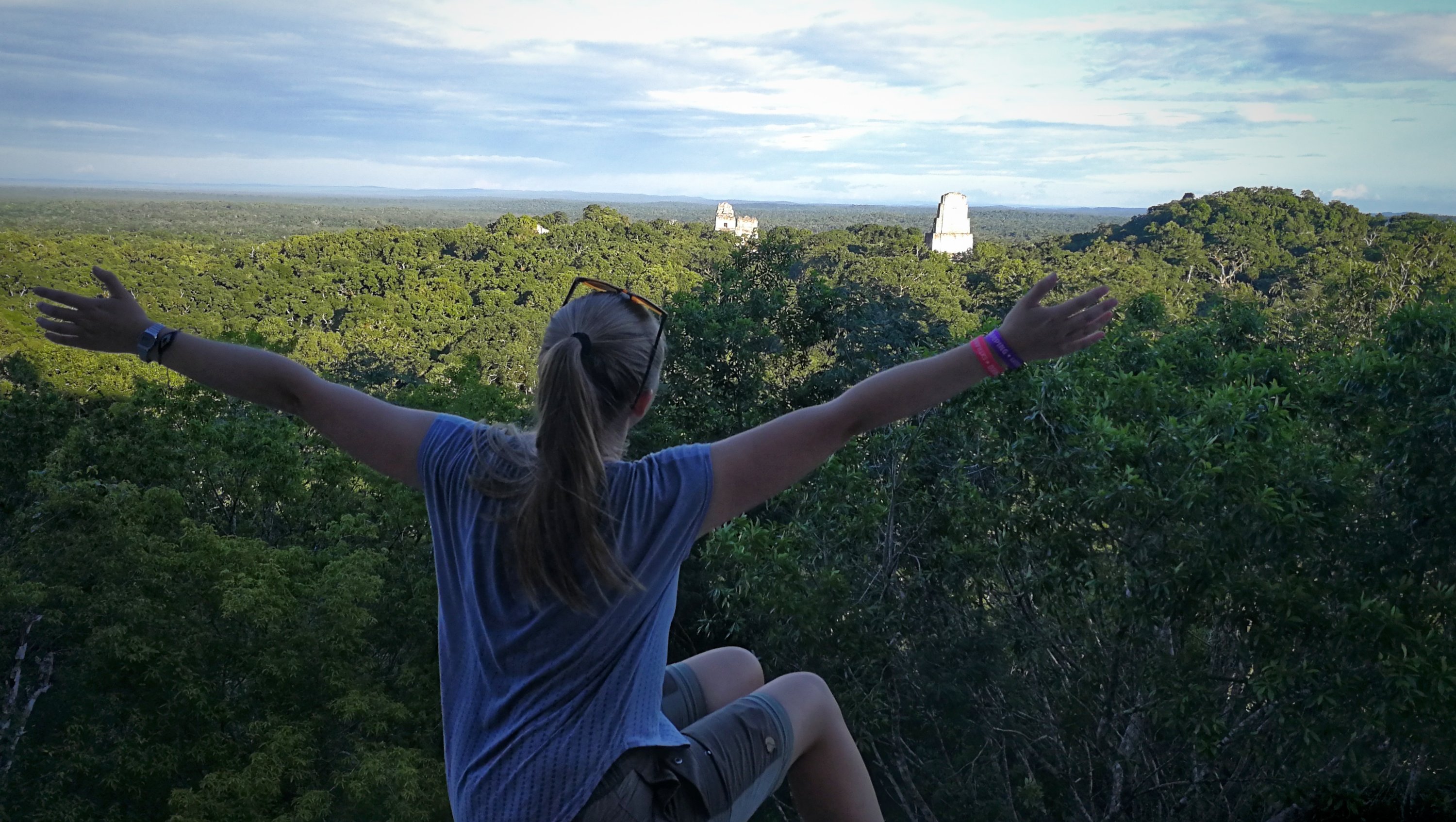 A woman enjoying the view atom Templo IV in Tikal National Park, Guatamala