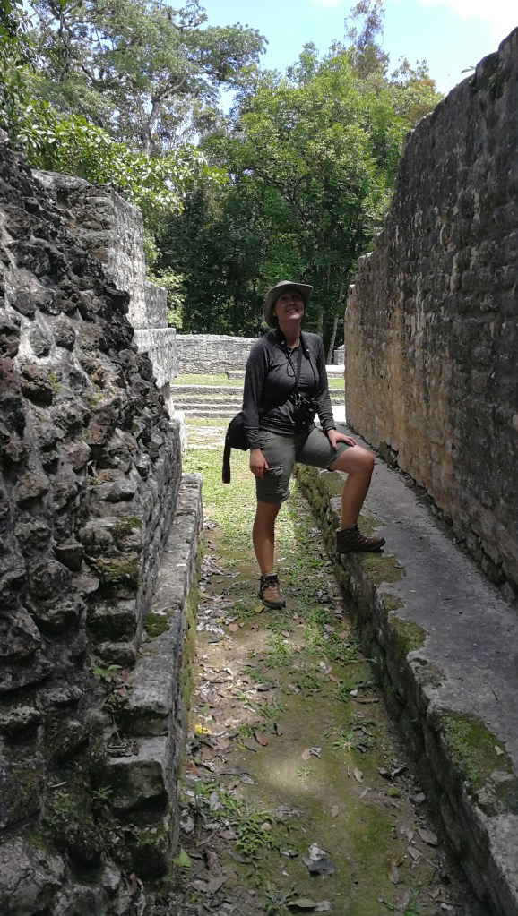 Woman (myself) looking up and being practically dressedand adventurous in a Mayan ruin in Belize.
