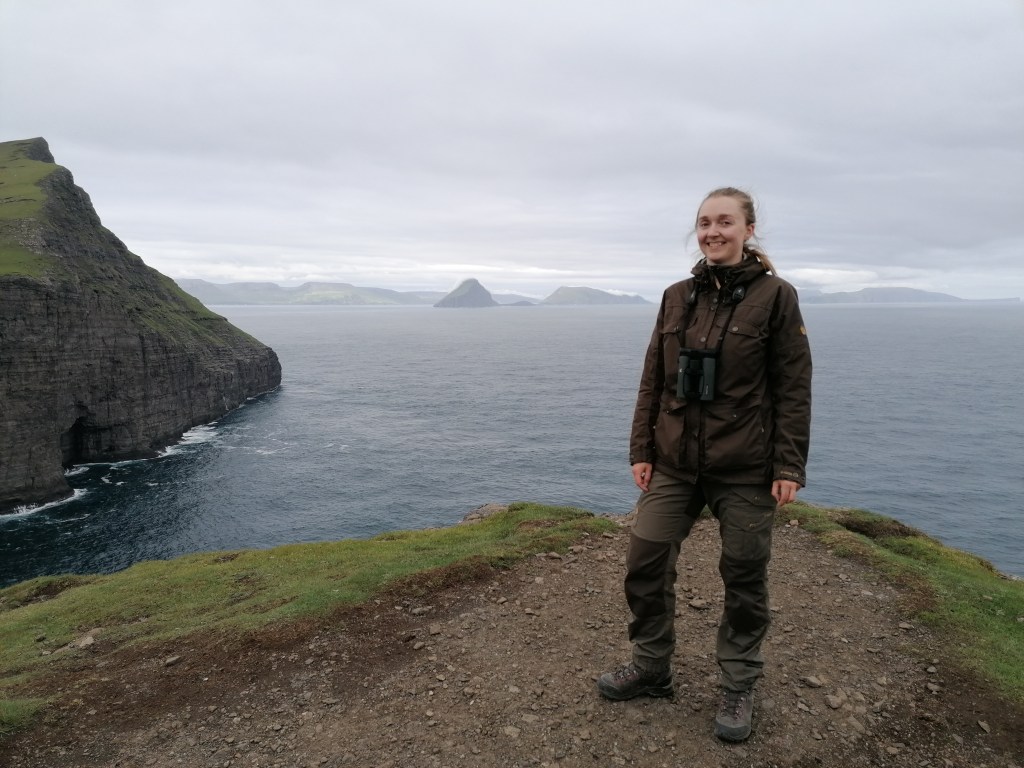 Rie (author) standing in front of the cliff Trælanípa