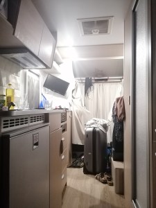 Inside the autocamper. A messy place with a big suitcase on the floor