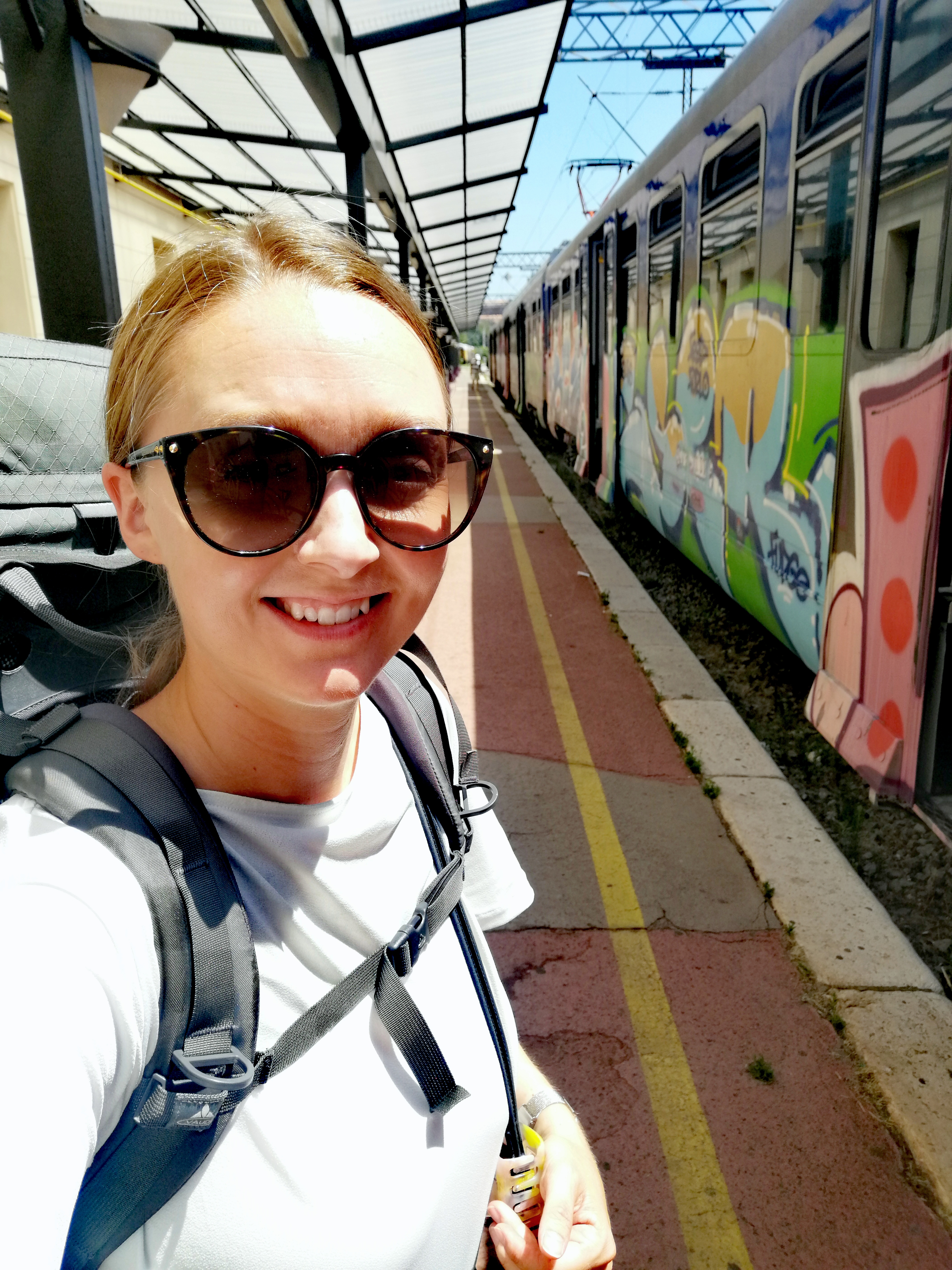 Rie with her backpack on a train station in Croatia
