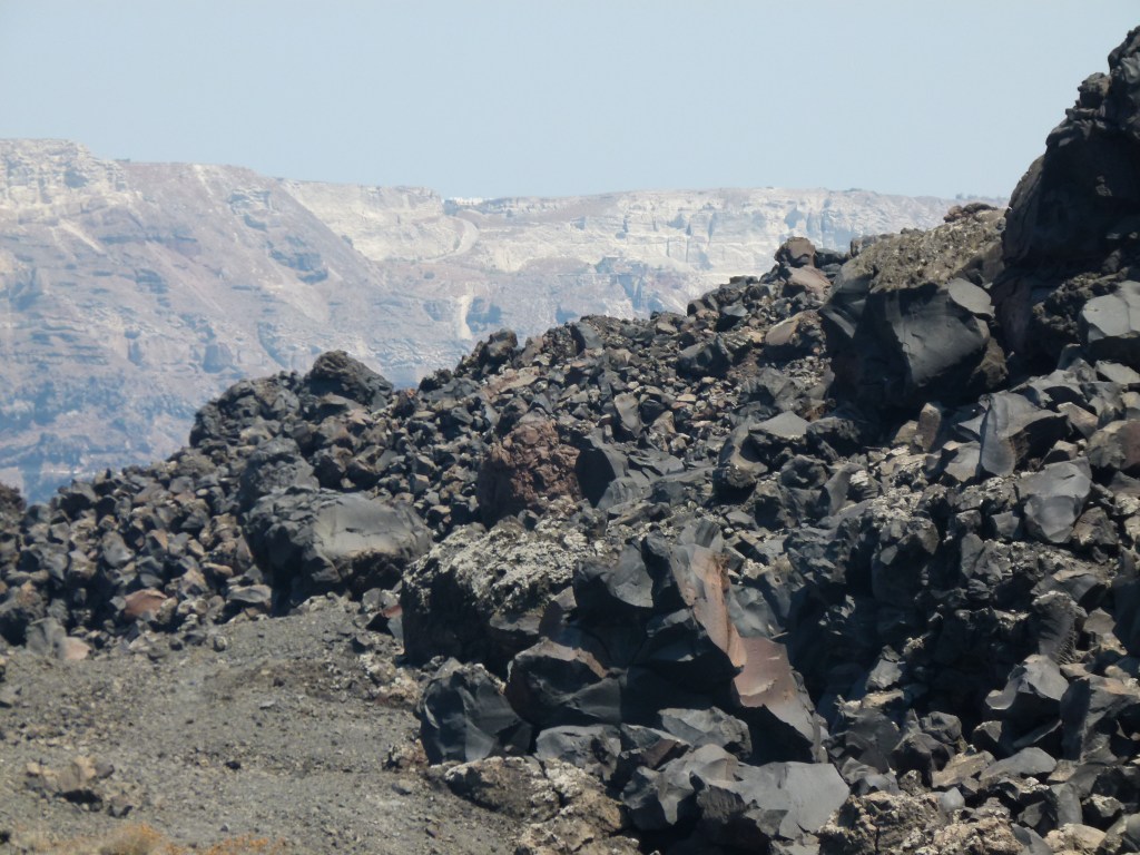 Black lava rocks on Tholos Naftilos, Greece